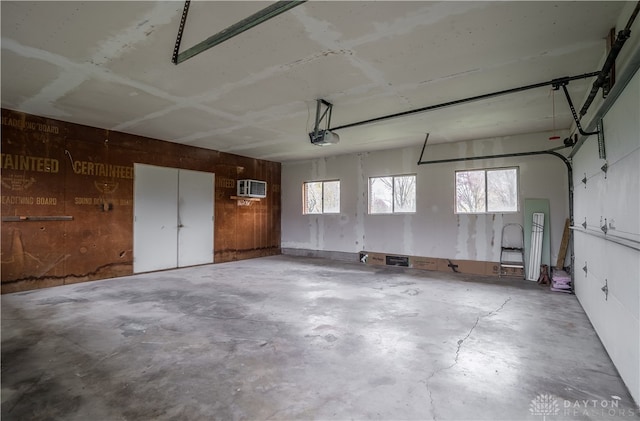 garage featuring a wall unit AC and a garage door opener