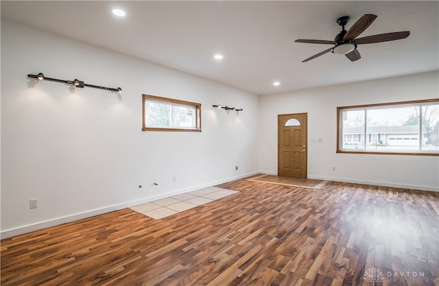 unfurnished room featuring wood-type flooring, a wealth of natural light, and ceiling fan