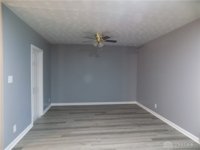 empty room featuring a textured ceiling, light hardwood / wood-style floors, and ceiling fan