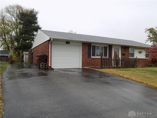 single story home featuring a front lawn and a garage