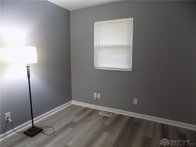 unfurnished room with wood-type flooring