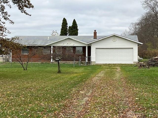 ranch-style house featuring a garage, driveway, and a front lawn