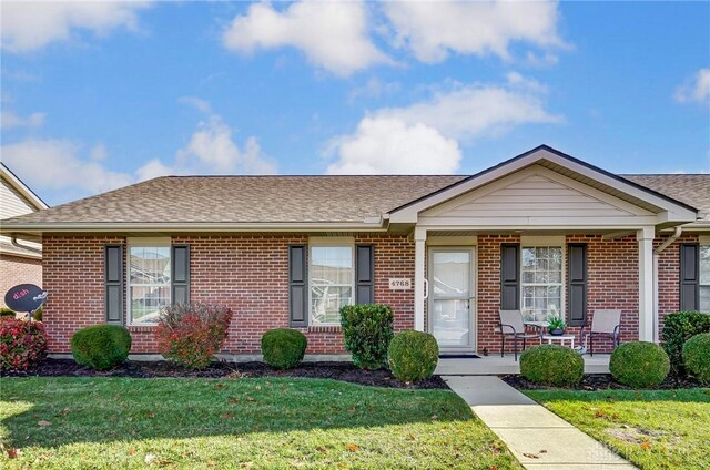 view of front of home with a porch and a front lawn