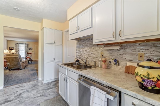 kitchen featuring white cabinetry, sink, backsplash, and stainless steel dishwasher