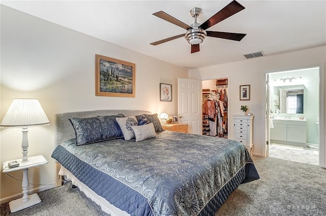 carpeted bedroom featuring connected bathroom, a spacious closet, a closet, and ceiling fan