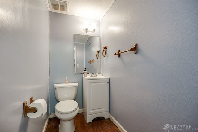 bathroom with crown molding, vanity, wood-type flooring, and toilet