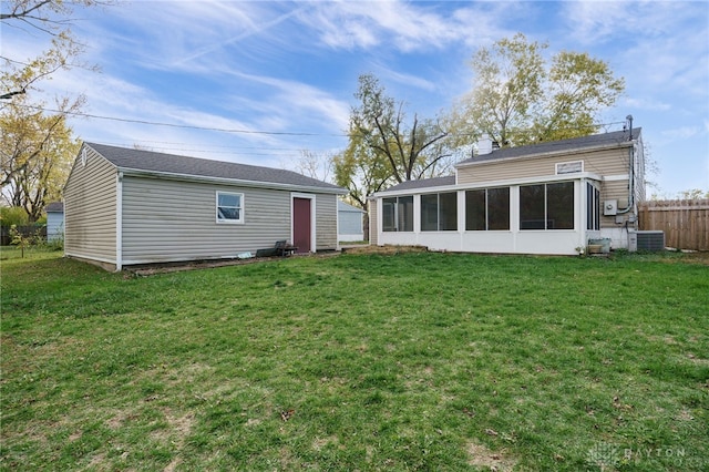 back of house featuring a lawn and central AC unit