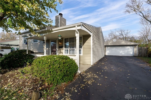 view of front of house featuring a porch, a garage, and an outdoor structure