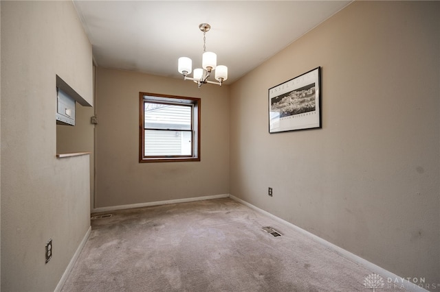 carpeted empty room with a chandelier