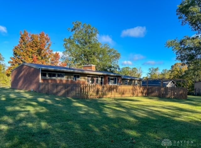 rear view of house featuring a lawn