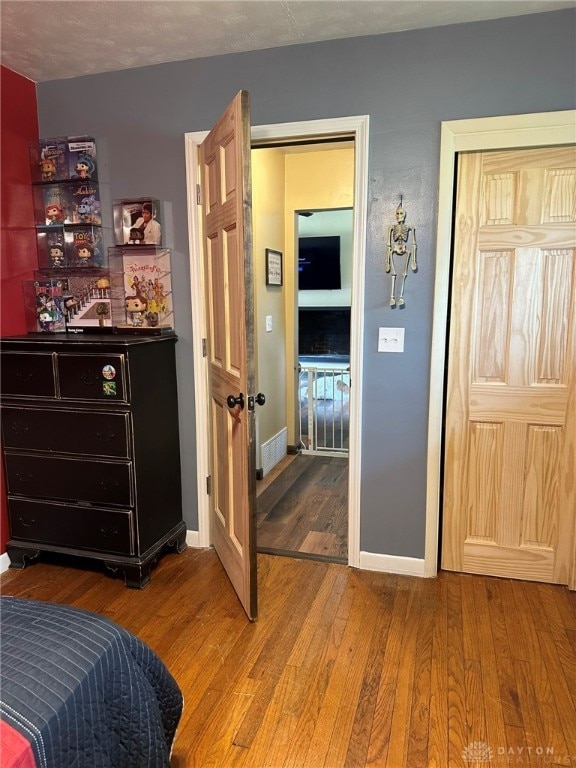 bedroom with a textured ceiling and hardwood / wood-style flooring