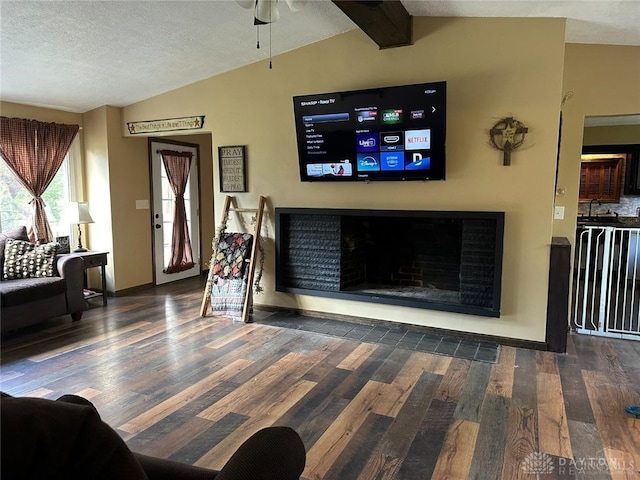 living room featuring a textured ceiling, sink, vaulted ceiling with beams, and dark hardwood / wood-style flooring