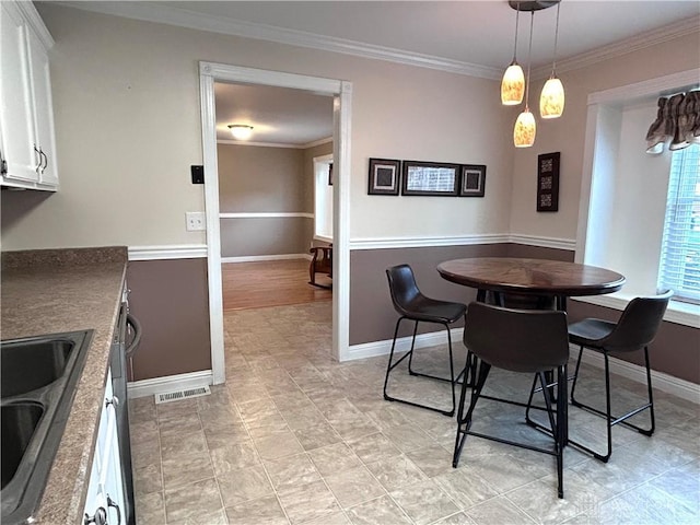 dining space featuring ornamental molding and sink