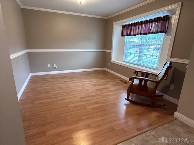 unfurnished room featuring light wood-type flooring and ornamental molding