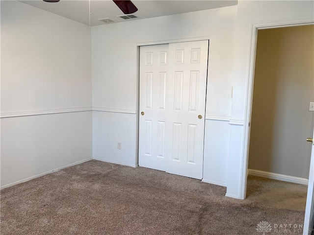 unfurnished bedroom with carpet flooring, ceiling fan, and a closet