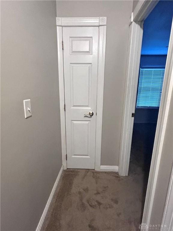 hallway featuring dark colored carpet