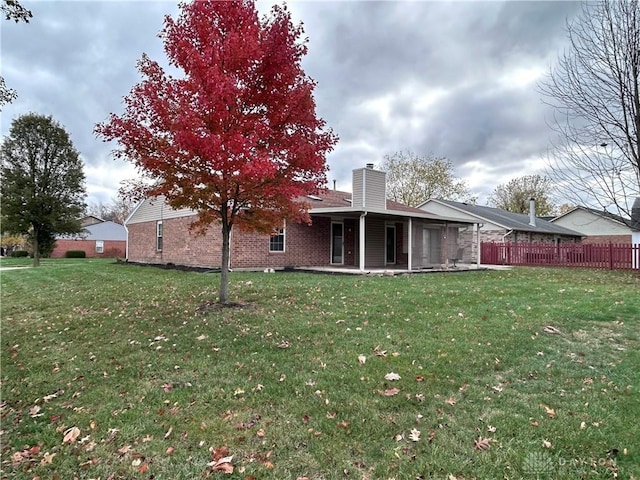 rear view of property featuring a lawn