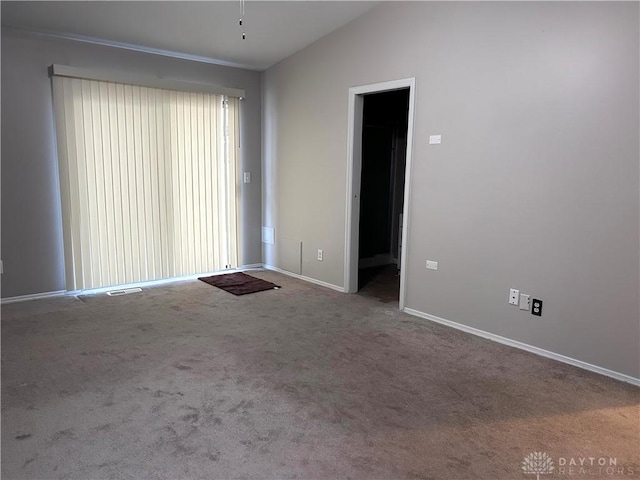 empty room featuring carpet floors and lofted ceiling