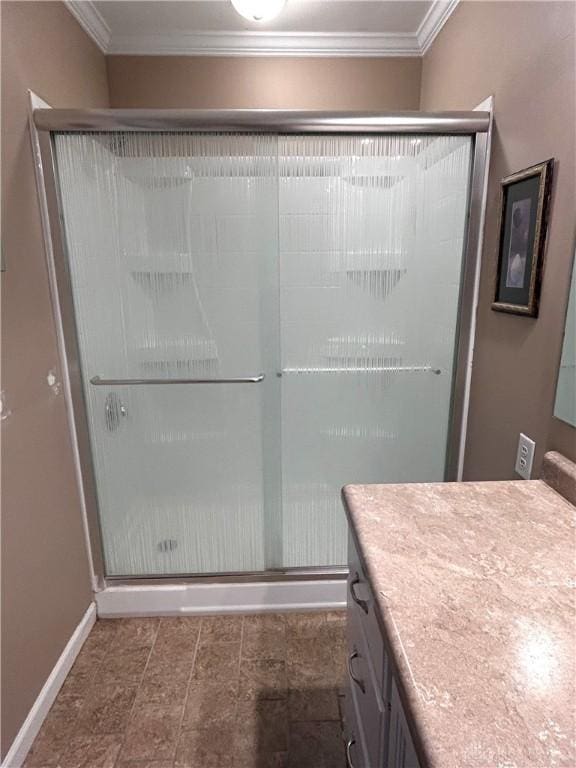 bathroom featuring vanity, a shower with shower door, and ornamental molding