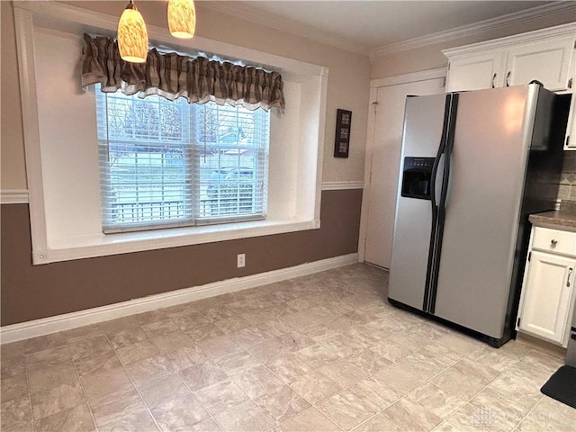 kitchen with stainless steel refrigerator with ice dispenser, pendant lighting, white cabinetry, and crown molding