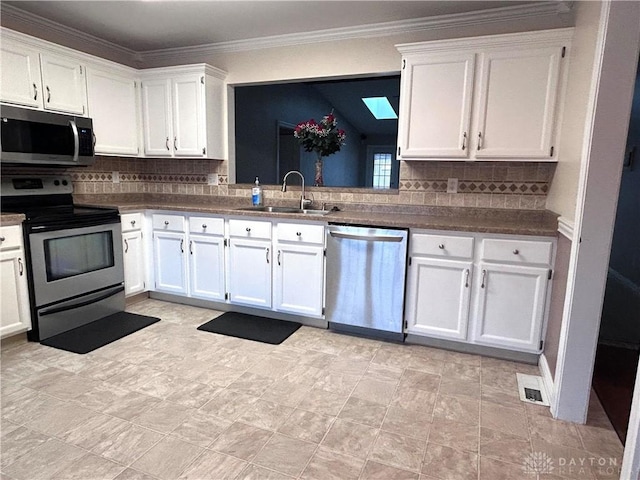 kitchen with white cabinetry, sink, stainless steel appliances, crown molding, and decorative backsplash