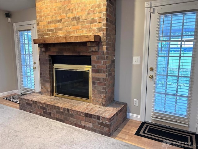 interior space with hardwood / wood-style floors, a brick fireplace, and plenty of natural light