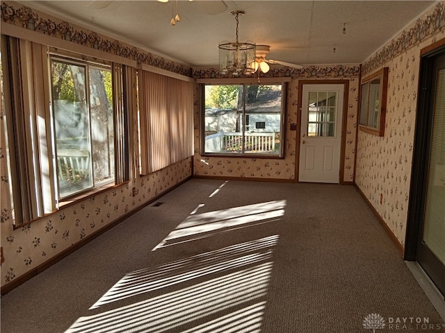 unfurnished sunroom with ceiling fan