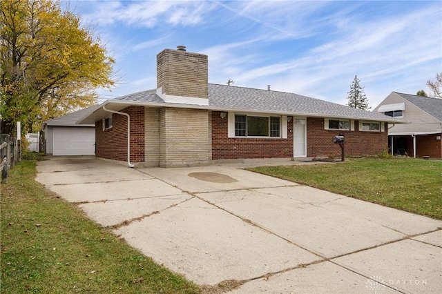 ranch-style home with an outbuilding, a front yard, and a garage