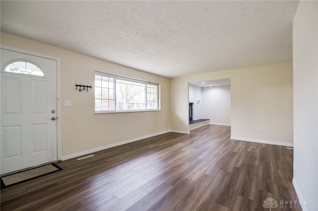 entryway featuring dark hardwood / wood-style flooring, a healthy amount of sunlight, and a textured ceiling