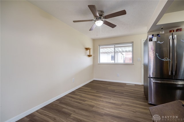 kitchen featuring stainless steel refrigerator, ceiling fan, dark wood-type flooring, and a textured ceiling