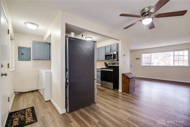 kitchen featuring hardwood / wood-style floors, appliances with stainless steel finishes, gray cabinets, and independent washer and dryer