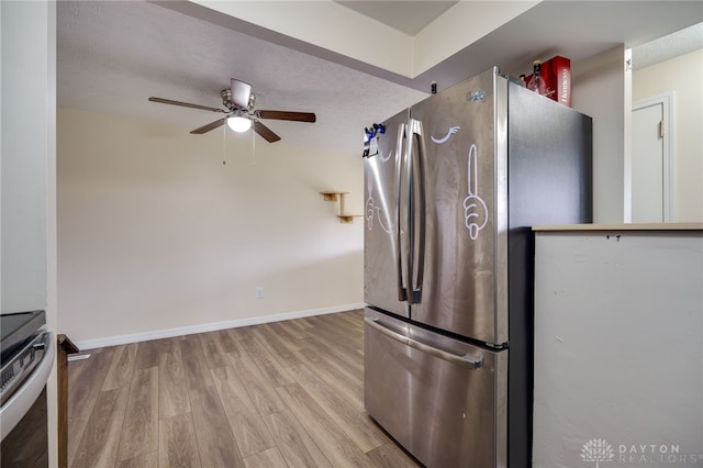 kitchen featuring a textured ceiling, light wood-type flooring, stainless steel appliances, and ceiling fan