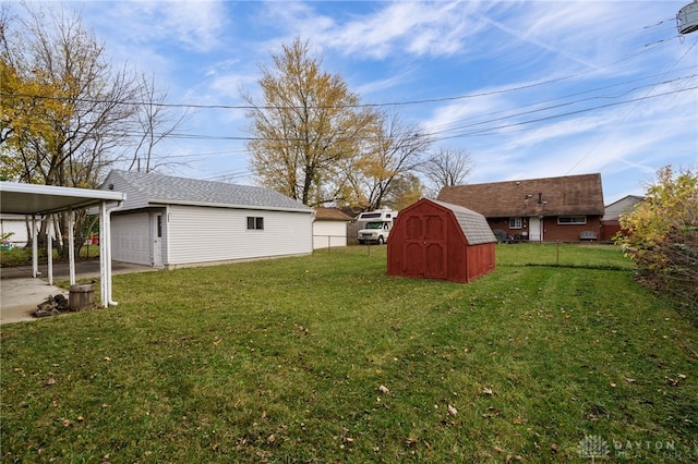 view of yard with a carport, a garage, and a storage unit