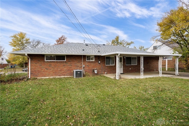 rear view of property with a lawn, central AC unit, and a patio area