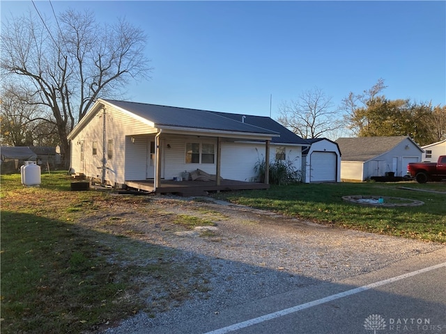 view of front of property with a front yard, an outdoor structure, a porch, and a garage