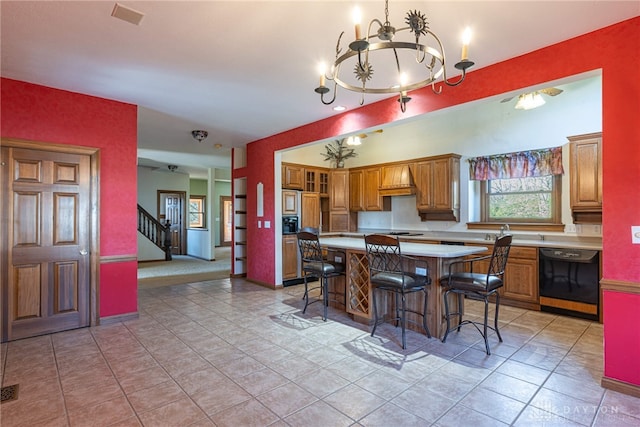 kitchen featuring black dishwasher, an inviting chandelier, a breakfast bar, custom exhaust hood, and a center island