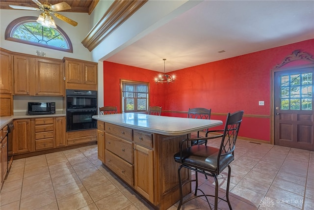 kitchen with ceiling fan with notable chandelier, light tile patterned floors, hanging light fixtures, a center island, and black double oven