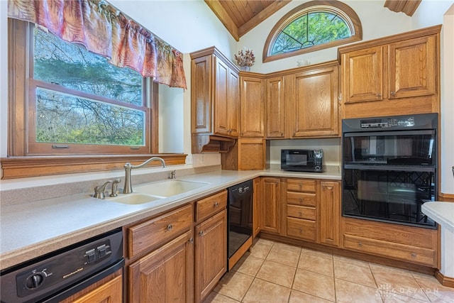 kitchen with black appliances, lofted ceiling, sink, and light tile patterned floors