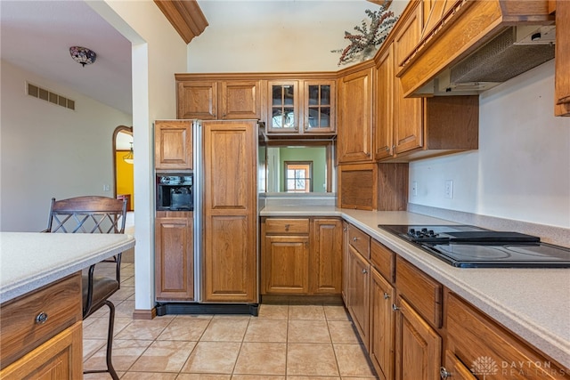 kitchen featuring black electric stovetop, light tile patterned floors, custom exhaust hood, and paneled refrigerator