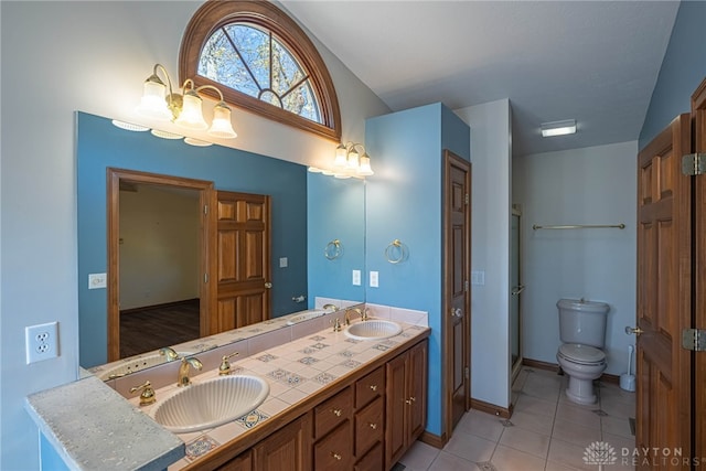 bathroom with tile patterned floors, vanity, toilet, and vaulted ceiling