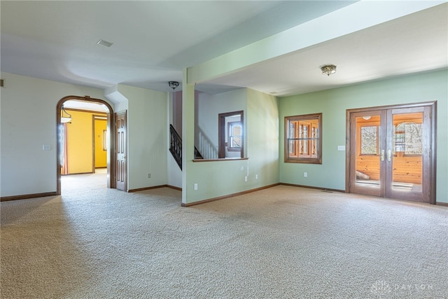 unfurnished living room featuring french doors and light colored carpet