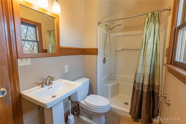 bathroom featuring walk in shower, tile patterned floors, and toilet