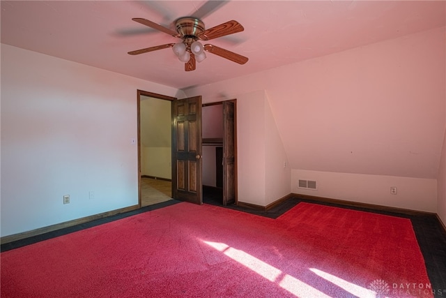 carpeted spare room with ceiling fan and lofted ceiling