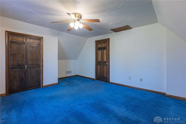 additional living space featuring ceiling fan, lofted ceiling, and dark carpet