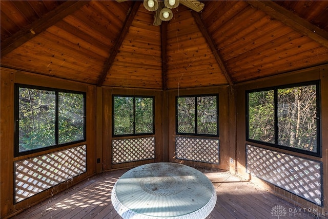 unfurnished sunroom featuring wooden ceiling, ceiling fan, and lofted ceiling with beams