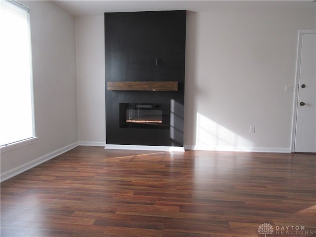 unfurnished living room with plenty of natural light and dark wood-type flooring