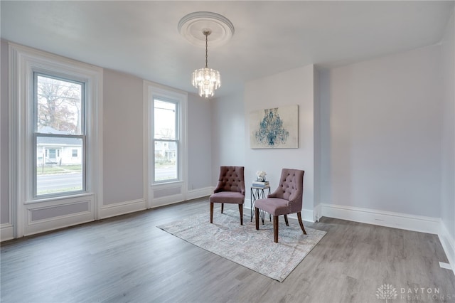 living area featuring a notable chandelier and light wood-type flooring