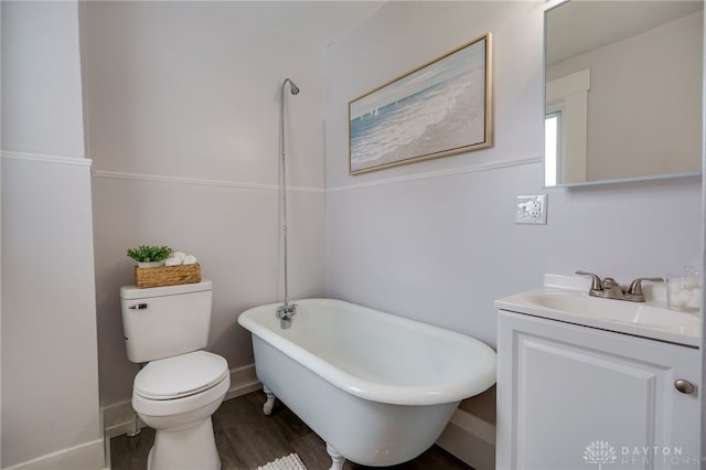 bathroom with a washtub, vanity, hardwood / wood-style floors, and toilet