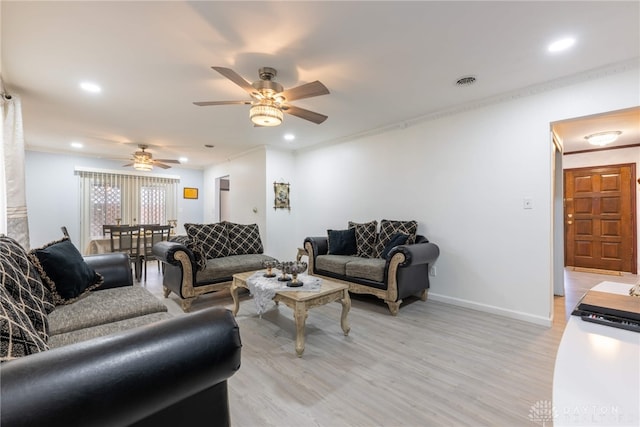 living room featuring light hardwood / wood-style flooring, ceiling fan, and crown molding