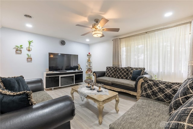 living room featuring light hardwood / wood-style floors and ceiling fan